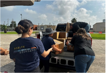 Volunteers unloading supplies from truck.