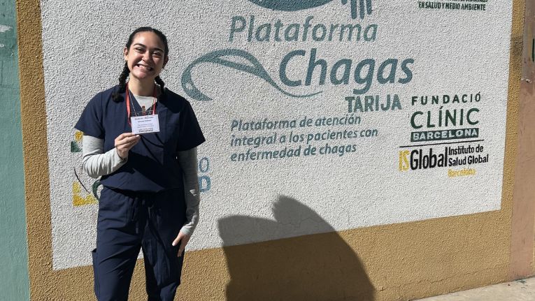 Jazzmyn Hollister pictured in Bolivia in front of wall art depicting Chagas clinic.
