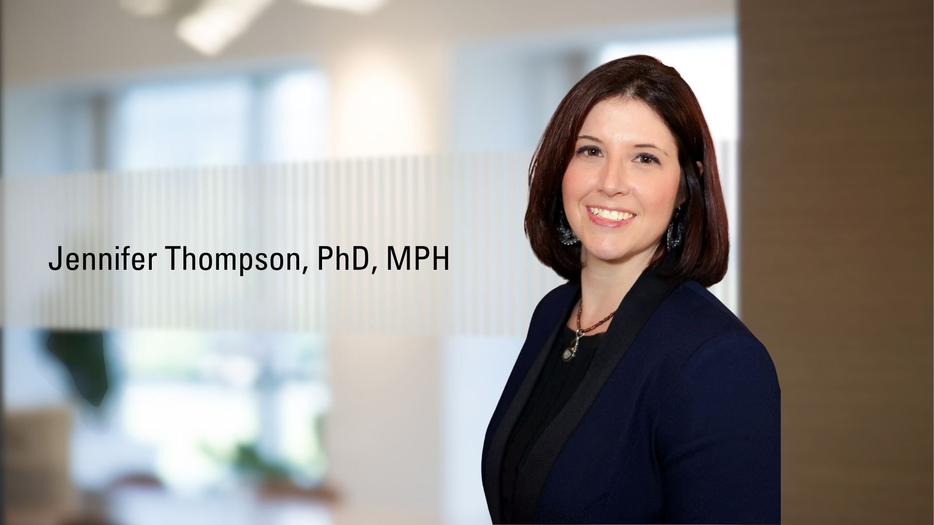 Jennifer Thompson, PhD standing in front of office windows