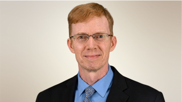 Casey Crump, MD, PhD, MPH,  professor in the Department of Family and Community Medicine at McGovern Medical School smiling in black suit and blue shirt. (Photo by UTHealth Houston)