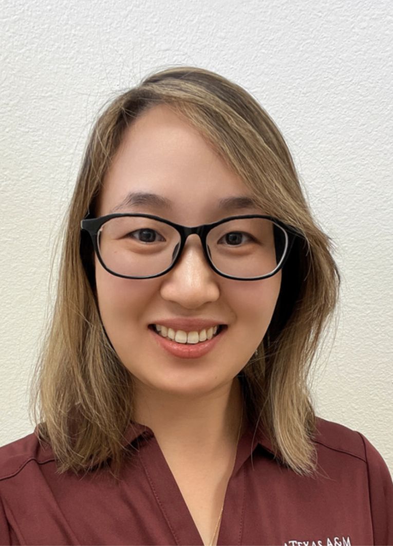 Jingjing Gao, PhD, smiling at camera wearing glasses and a maroon collard shirt.
