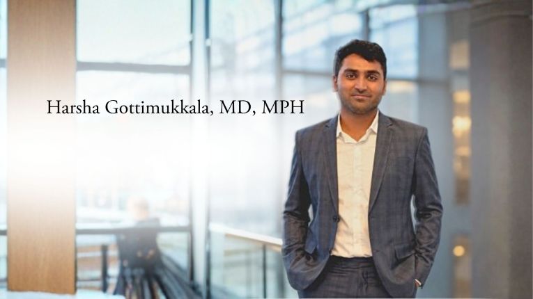 Harsha Gattimukkala, MD, MPH standing in front of office windows
