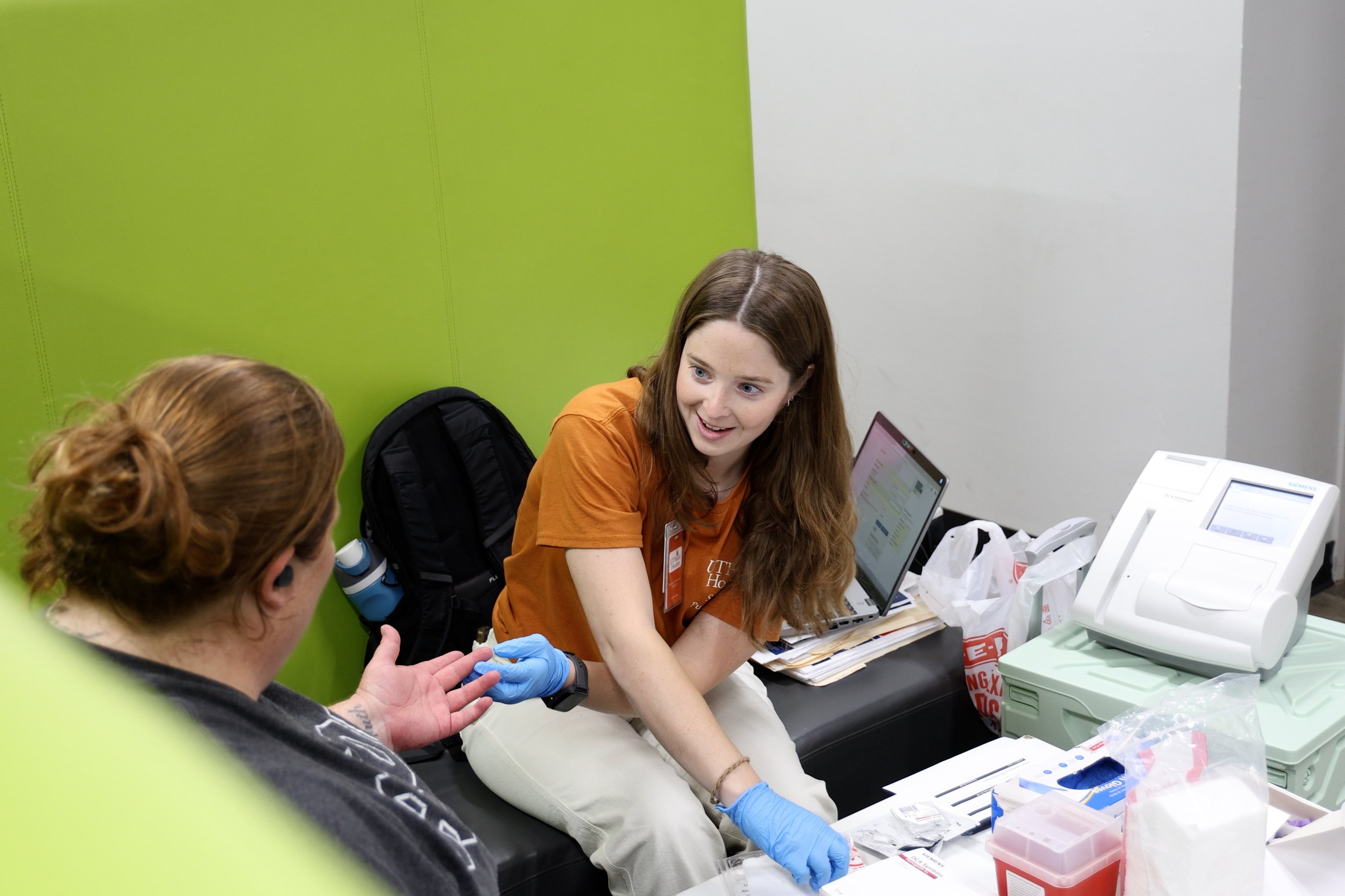 Taylor Downs, MPH ’26, administers an A1C test to a laundromat patron at a recent SPIN Project clinic.
