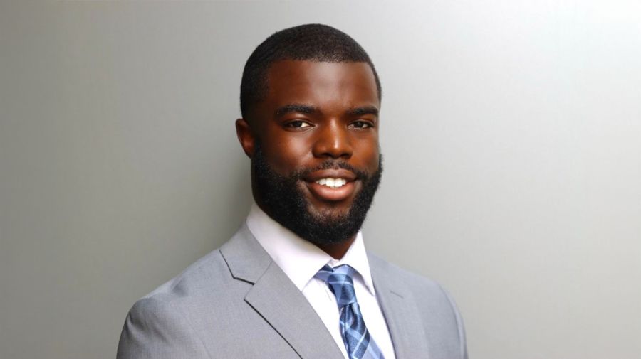 Mr. Stallings smiling and wearing a gray suit with white shirt and blue and white tie.