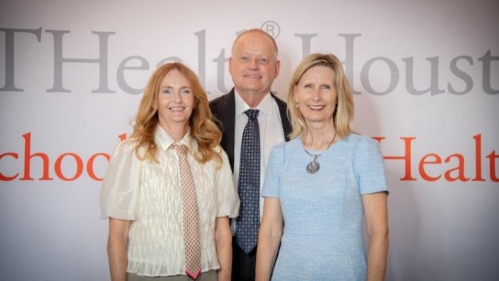 Two women and one man in front of 